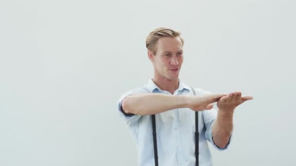 Muscular guy with fair hair performs gesture of rich man — Stock video