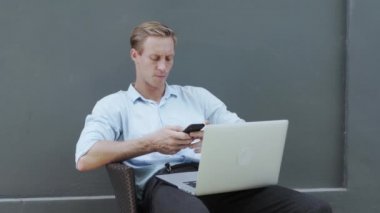 handsome blond man looks at modern white laptop display