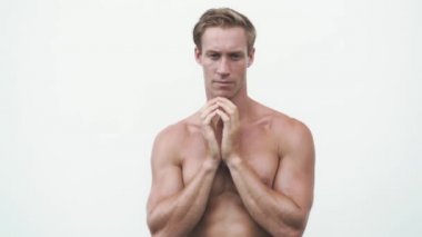 Çıplak gövdeli sarışın adam stüdyoda farklı duygular oynuyor.