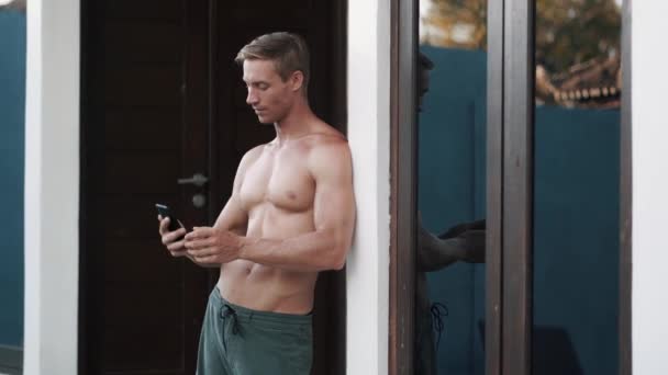 Pria ceria membuat selfie dengan smartphone dekat pintu — Stok Video