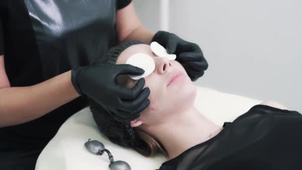Esteticista se pone gafas protectoras en los ojos de la mujer antes del tratamiento facial — Vídeo de stock