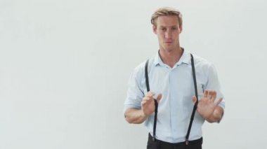 handsome blond in white shirt looks straight and dances