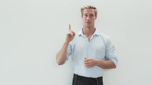 Guapo musculoso hombre en blanco camisa plantea índice dedo — Vídeos de Stock