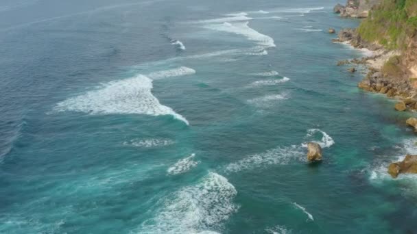 Видео с флайкамом океаническая вода и волны катятся по скалистому острову — стоковое видео