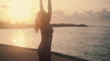 girl with slim body raises and lowers hands stretching