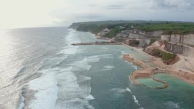 flight above beautiful ocean waves rolling on steep beach