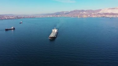 flycam films long white freight vessel crossing clear water