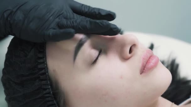 De cerca, mujer disfrutando de masajes faciales relajantes en el centro de cosmetología — Vídeo de stock