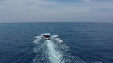 Turist beyaz ve mavi motorlu tekne katamaran yelkenleri okyanusta