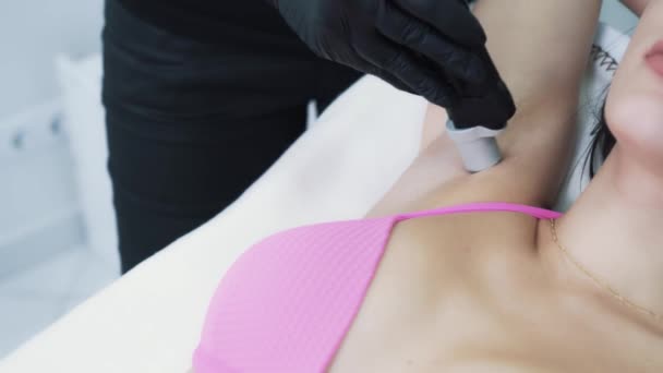 Woman in cosmetology clinic on procedure of laser hair removal of armpit area — Stockvideo