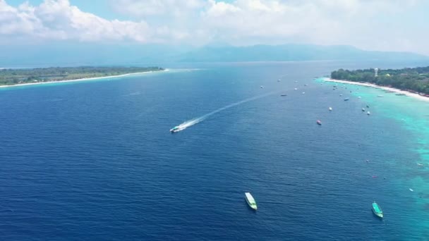 Motorboat speeds on calm blue ocean between islands aerial — Stock Video