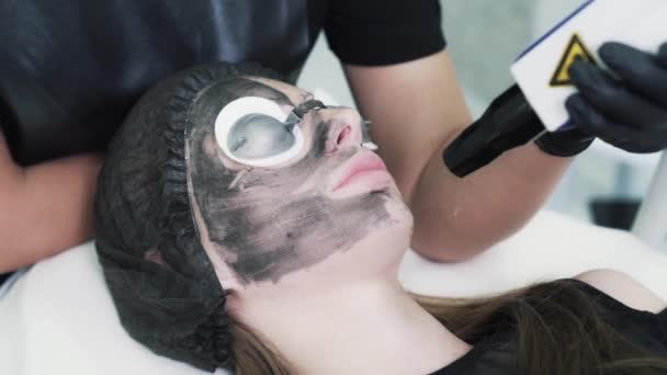 Slow-motion, vrouw in beschermende bril op carbon face peeling procedure — Stockvideo