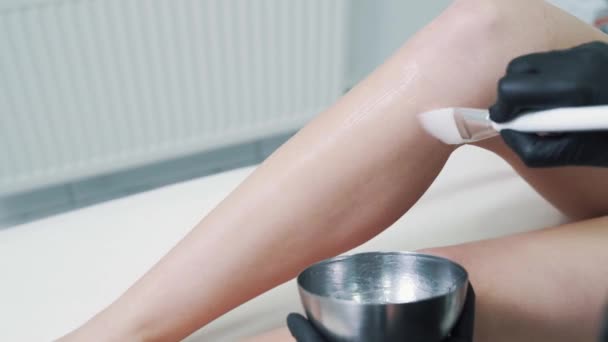 Le mani del medico applicano gel speciale sulla gamba della donna prima della procedura di depilazione laser — Video Stock