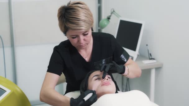Schoonheidsspecialiste doet hydro peeling procedure op vrouw gezicht in de medische kliniek — Stockvideo