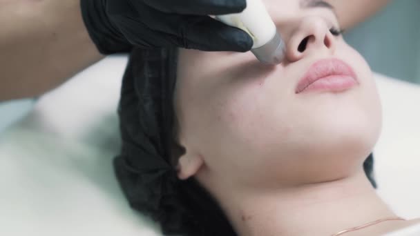 Close-up, beautician does moisturizing procedure on woman face at clinic — Stock Video