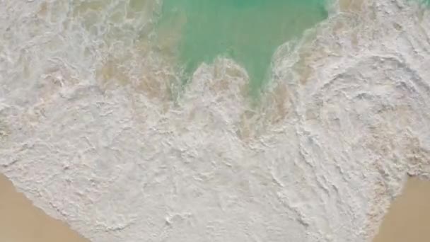 Vue aérienne du haut vers le bas de l'eau bleue azur, vagues de l'océan s'écrasant sur la plage de sable — Video