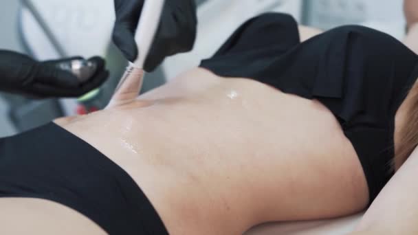 Beautician hands applies special gel on woman stomach before lifting procedure — Stock Video