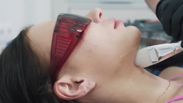 Косметик нанес специальный гель с кистью на лицо пациента перед процедурой лечения — стоковое видео