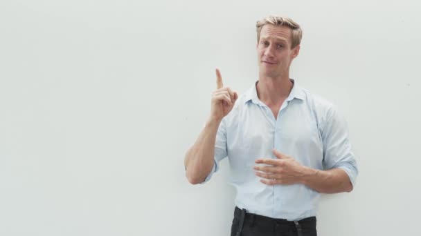 Красивий м'язистий чоловік у білій сорочці піднімає індексний палець — стокове відео