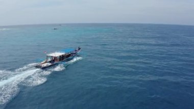 Turist beyaz ve mavi motorlu tekne katamaran yelkenleri okyanusta