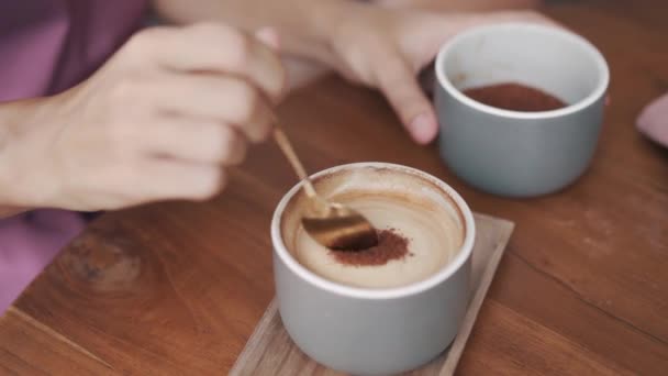 Κοντινό πλάνο, φλιτζάνι καφέ, γυναικείο χέρι βάζει καφέ ζάχαρη στο ρόφημα — Αρχείο Βίντεο