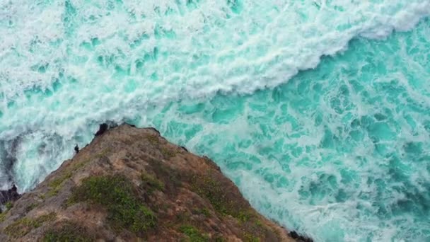 Hermoso azul ondulación olas del océano rodean alta roca marrón — Vídeo de stock