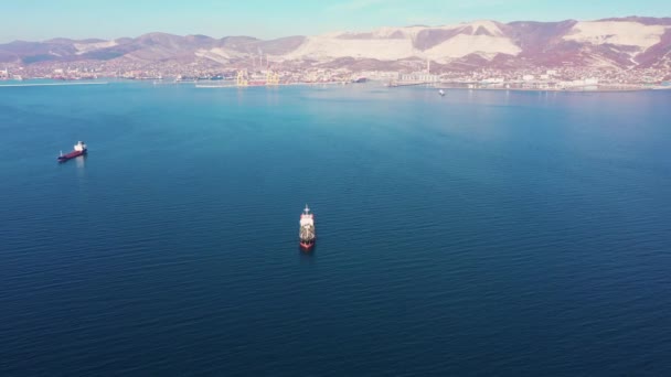 Vue aérienne suivant l'ultra grand cargo en mer quitte le port au coucher du soleil