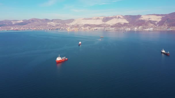 空中ビュー、船は丘陵海岸に対して穏やかな青い海の表面にドリフト — ストック動画