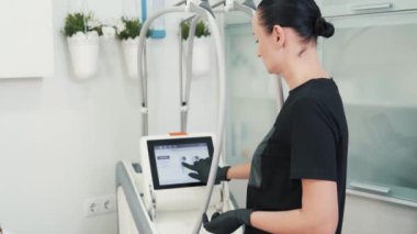 Güzel genç bayan güzellik uzmanı, sergilenen programı ve klinik ekipmanlarını seçti