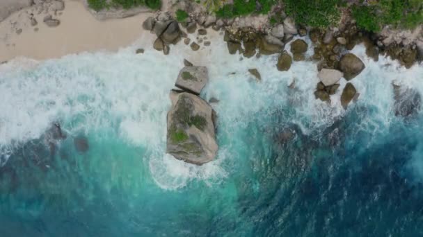 Luftaufnahme von oben, azurblaues Wasser, schäumende Meereswellen, die auf einen wilden Strand krachen — Stockvideo