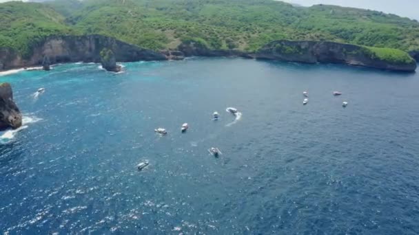 Vista aérea de barcos flutuando no oceano azul na baía da ilha, Nusa Penida, Bali — Vídeo de Stock