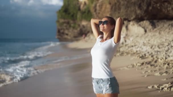 Jovem mulher bonita magro goza de férias na praia do oceano, ondas de espuma — Vídeo de Stock