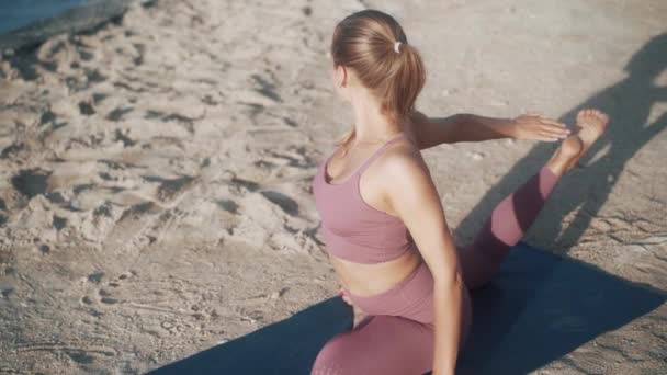 Mujer hace ejercicios de yoga, se extiende por la mañana con vista al océano, cámara lenta — Vídeo de stock