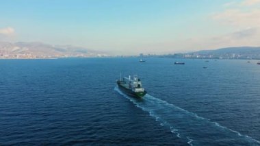Güneşli bir günde sakin mavi denizde seyreden tankerin hava görüntüsü.