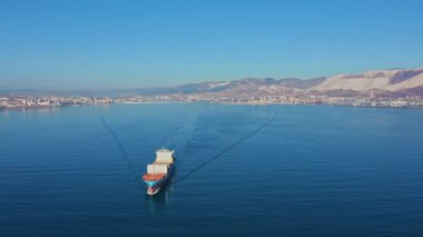 Ticari deniz limanından kargo taşıyan konteyner gemisinin hava görüntüsü.