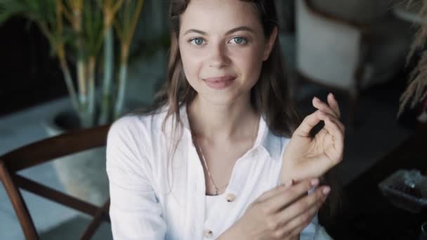 Portrait de belle femme brune dans un café, regardant la caméra — Video