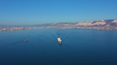 Ticari deniz limanından kargo taşıyan konteyner gemisinin hava görüntüsü.