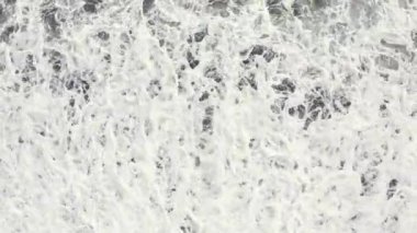 Volkanik kara kumsalın ve dev dalgaların güzel havadan görünüşü.