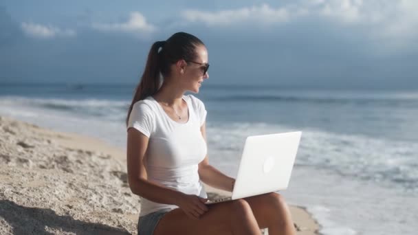 Side view of young cheerful woman working remotely — Stock Video