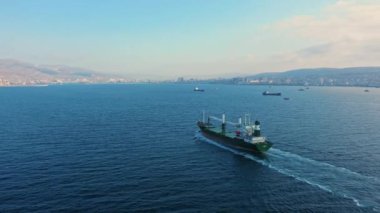 Güneşli bir günde sakin mavi denizde seyreden tankerin hava görüntüsü.
