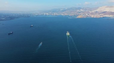 Güneşli bir günde sakin mavi denizde seyreden tankerin hava görüntüsü.