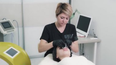 Genç bayan güzellik uzmanı bakım kremi kullanarak rahatlatıcı bir masaj yapıyor..
