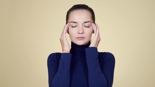 Портрет женщины, страдающей головной болью, изолированной на фоне бежевой студии — стоковое видео