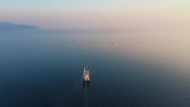 Luchtzicht na ultragroot vrachtschip verlaat haven bij zonsondergang — Stockvideo