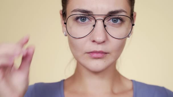 Retrato de mujer bonita con gafas sorprendida mirando a la cámara — Vídeo de stock