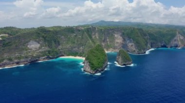 Nusa Penida Adası 'ndaki Kelingking Sahili' nin havadan görünüşü, gök mavisi okyanus, dağlar.