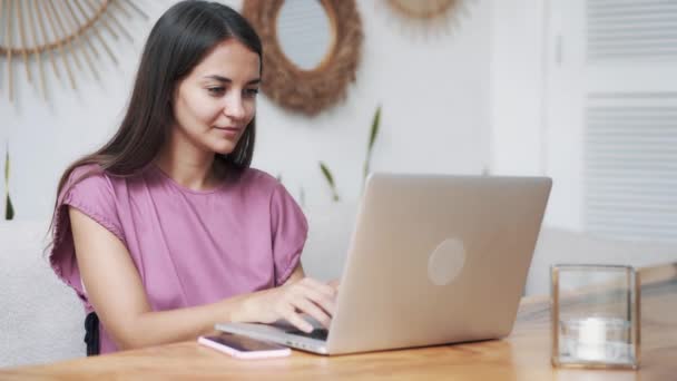 Портрет молодой женщины-фрилансера использует современный ноутбук для работы в стильном кафе — стоковое видео