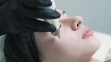 Kadın güzellik uzmanı genç ve güzel bir müşteriye hidro soyucu yapar.