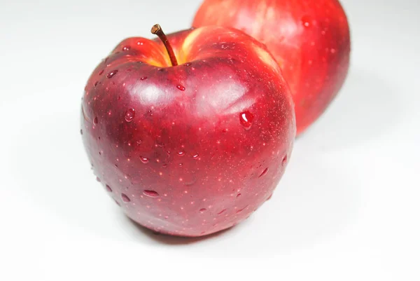 Pommes rouges juteuses fraîches sur une table blanche — Photo