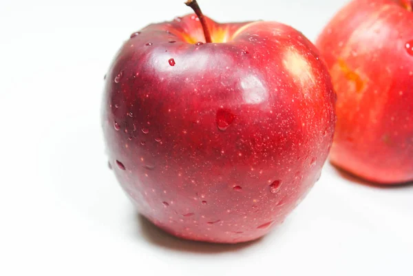 Pommes rouges juteuses fraîches sur une table blanche — Photo